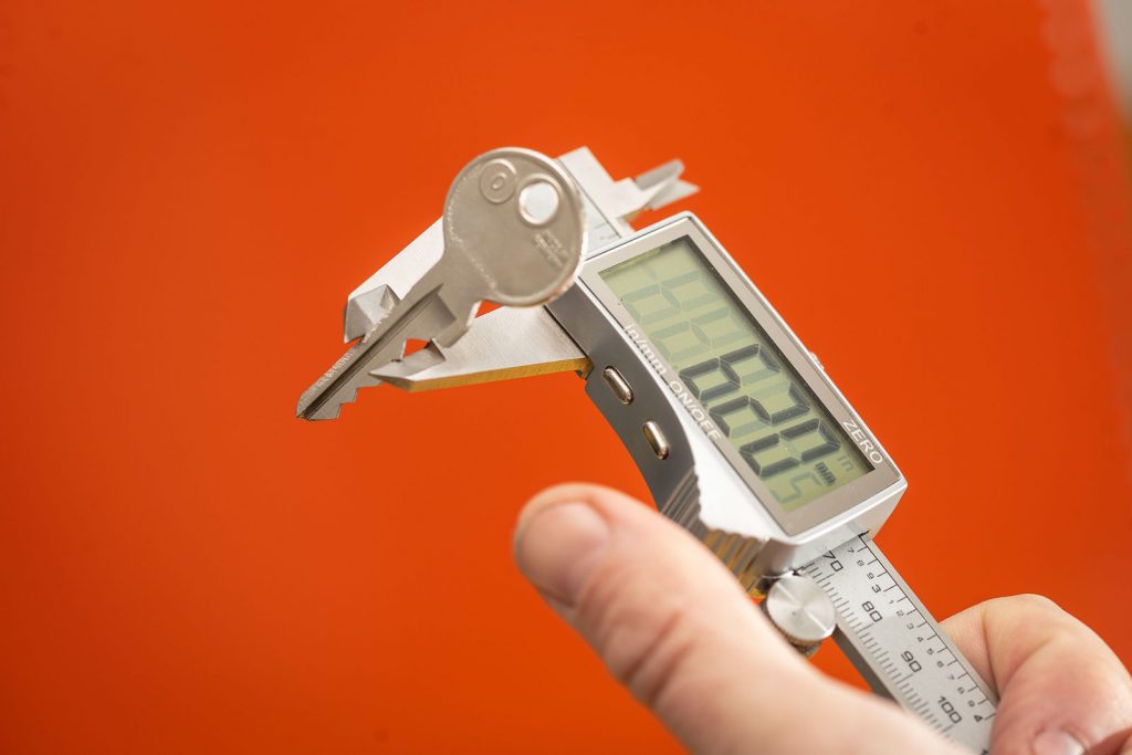 Eine Schlüsselkopie mit einer digitalen Schieblehre gemessen. Der Schlüsselrohling ist von Börkey.